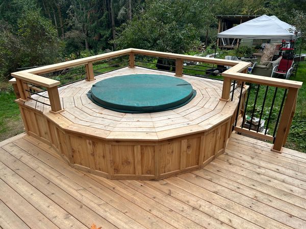 Cedar deck with an octagonal built-in hot tub surround and black metal railing
