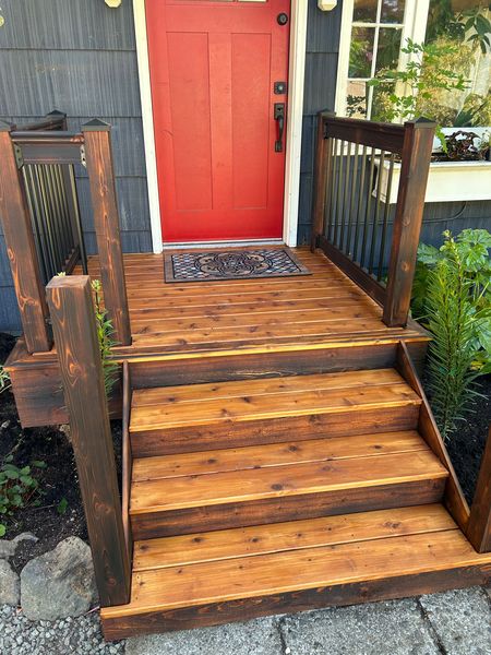 Cedar entry landing and steps with black balusters at a front door