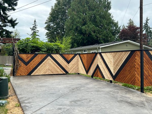 Cedar fence with a black-trimmed chevron pattern around a patio